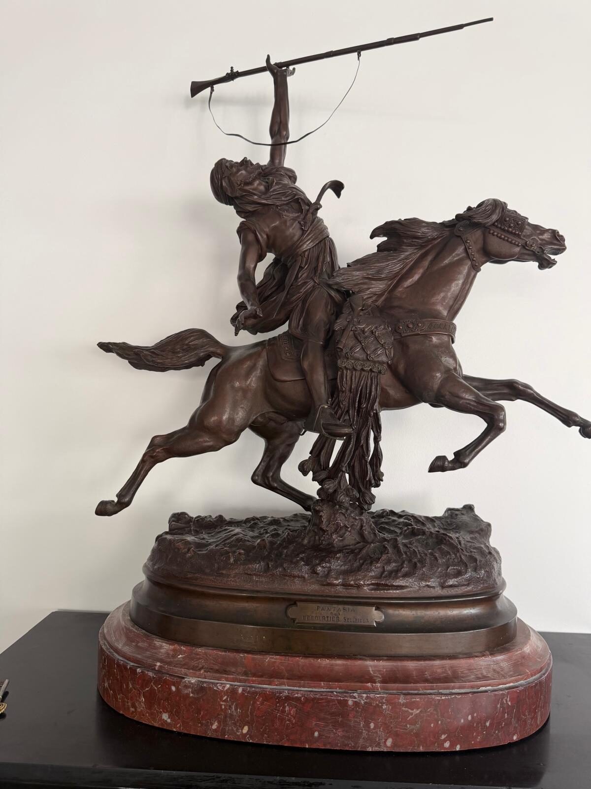 Bronze de Prosper Lecourtier : cavalier arabe en fantasia, fusil levé, sur un cheval au galop, crinière au vent, sur un socle de marbre rouge veiné