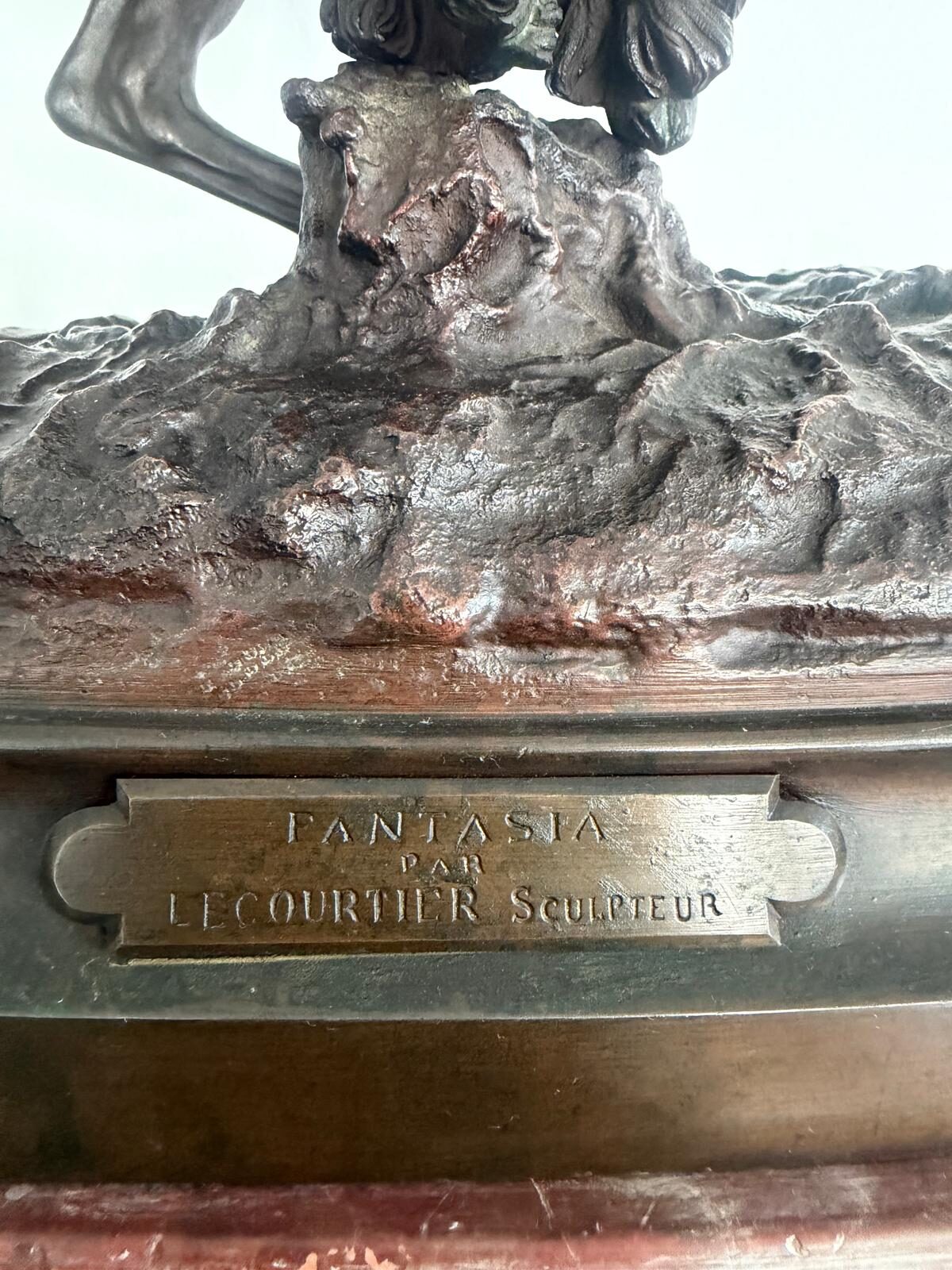 Plaque de bronze gravée « Fantasia par Lecourtier sculpteur », fixée sur le socle de marbre rouge
