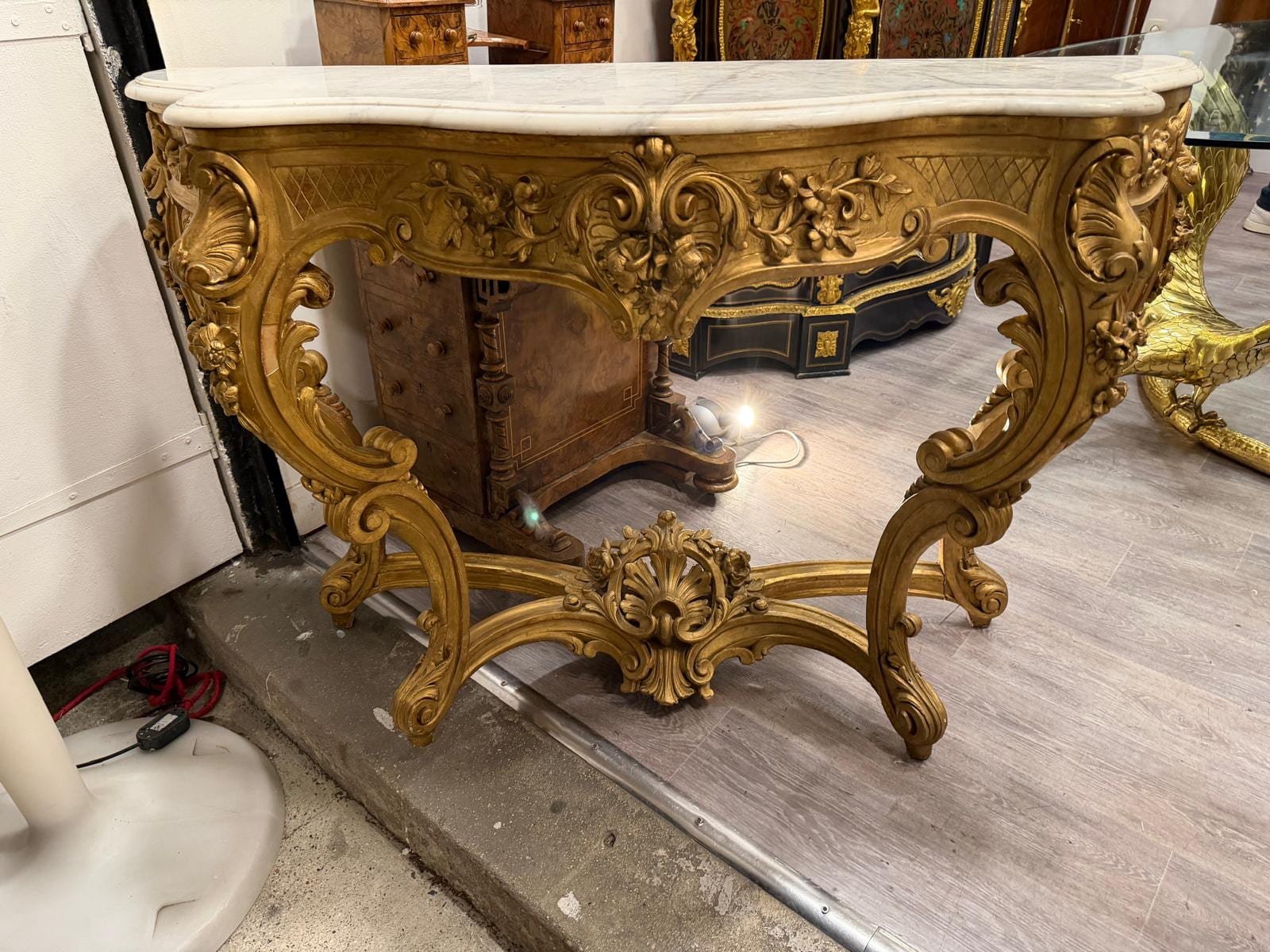 Console d'applique en bois sculpté et doré de style Louis XV, ceinture à coquille, pieds cambrés réunis par une entretoise, dessus de marbre blanc
