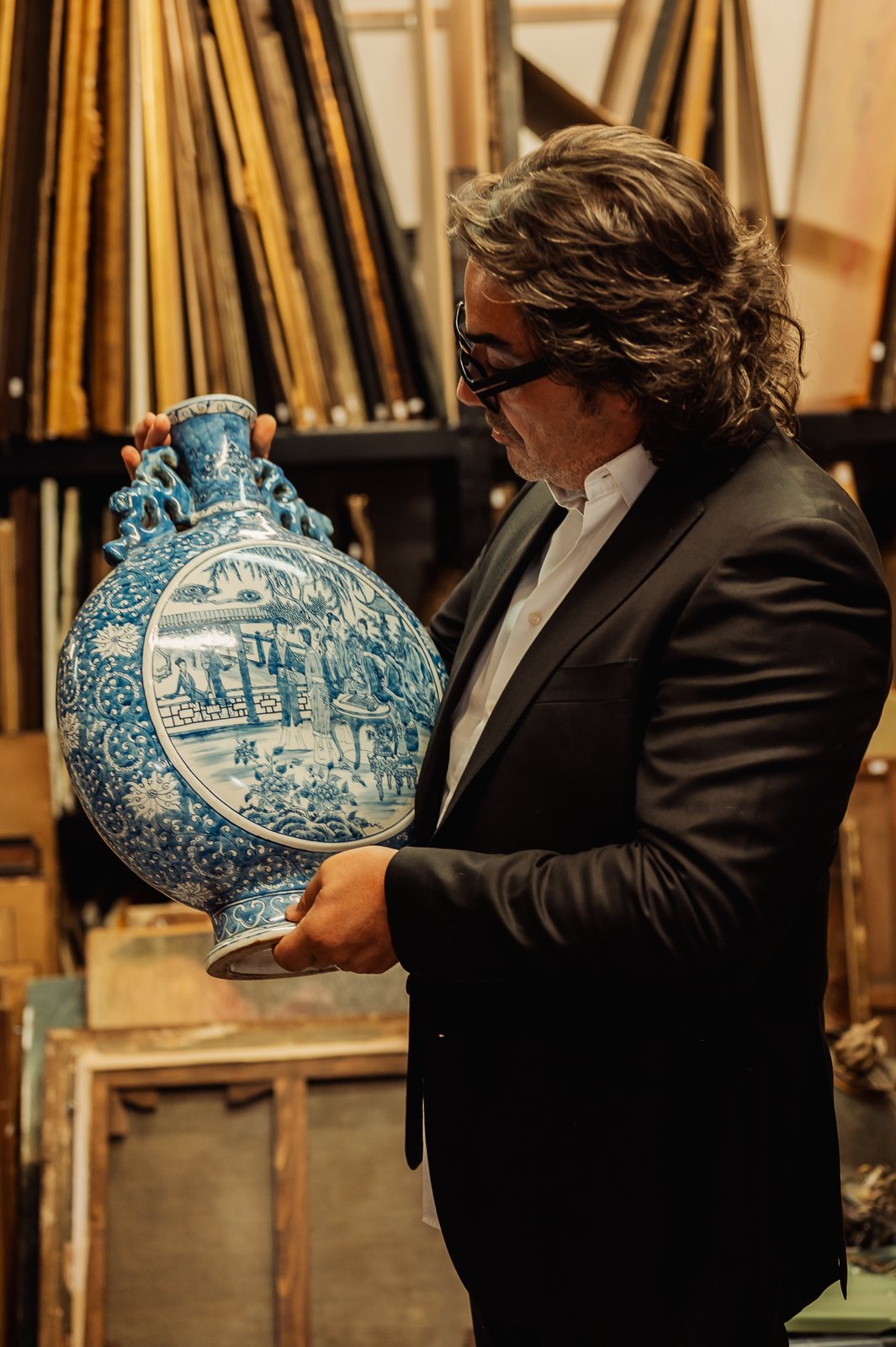 Éric tient une gourde en porcelaine chinoise bleu et blanc, médaillon central à scène de personnages dans un jardin