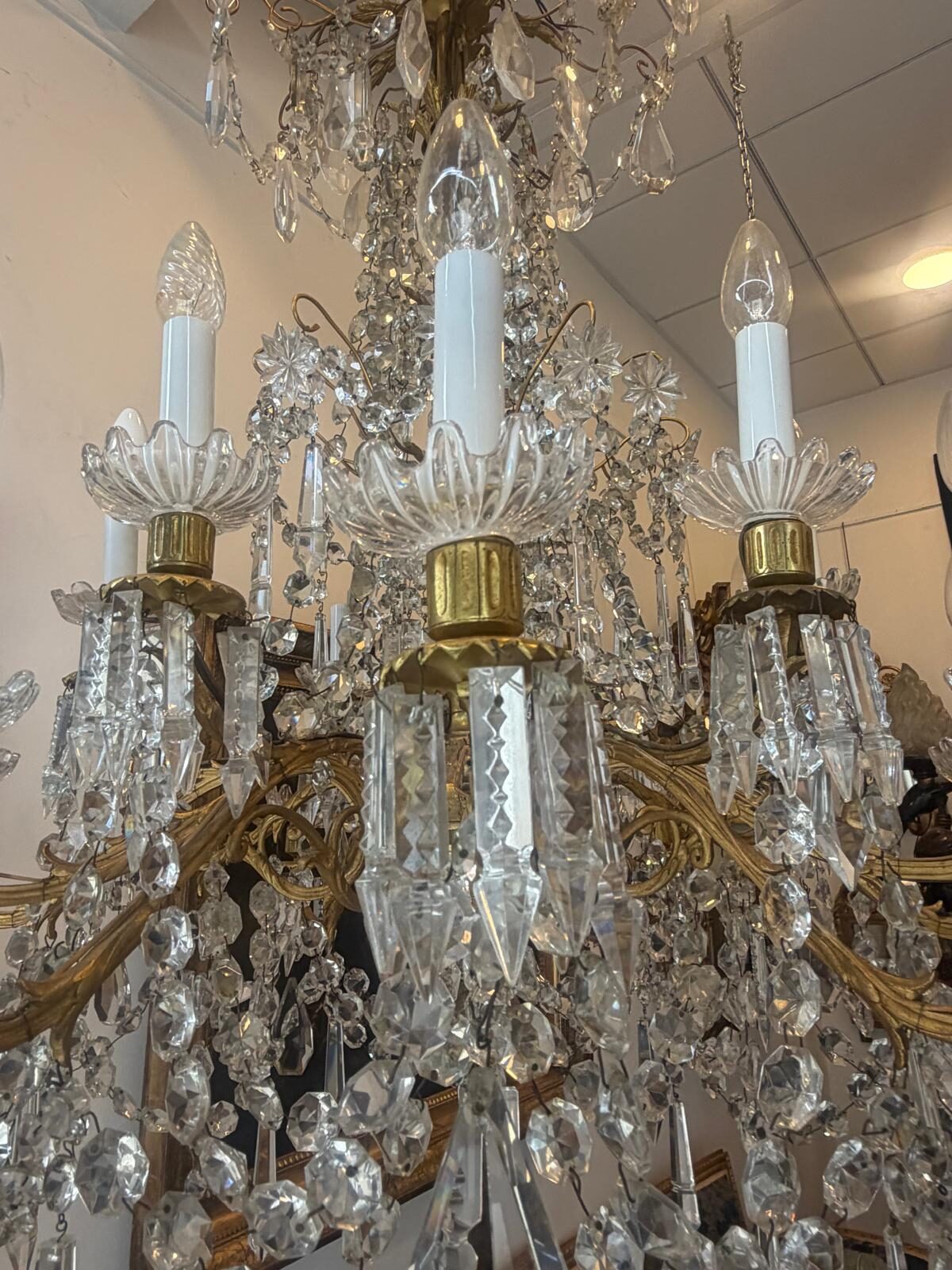 Bras du lustre : bobèches de cristal en corolle, binets de bronze doré, pampilles en pointes de diamant et plaquettes taillées