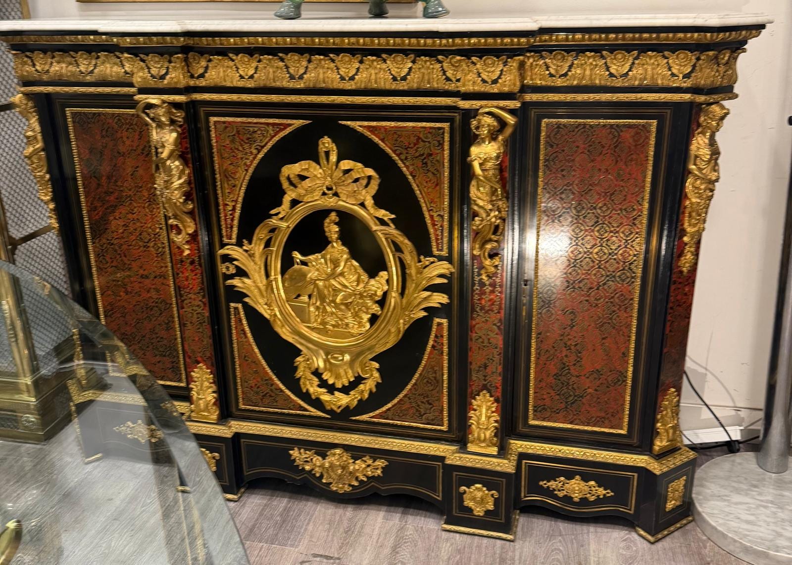 Meuble d'appui à trois portes en marqueterie Boulle de laiton sur fond rouge, médaillon central et cariatides en bronze doré, dessus de marbre blanc
