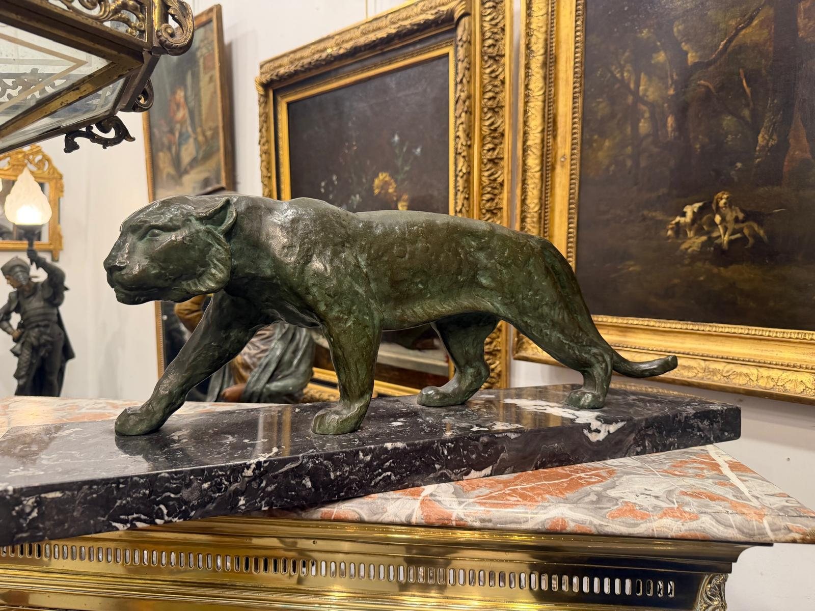 Panthère en marche en bronze à patine verte signée Garreau, sur socle de marbre noir veiné, dans la galerie