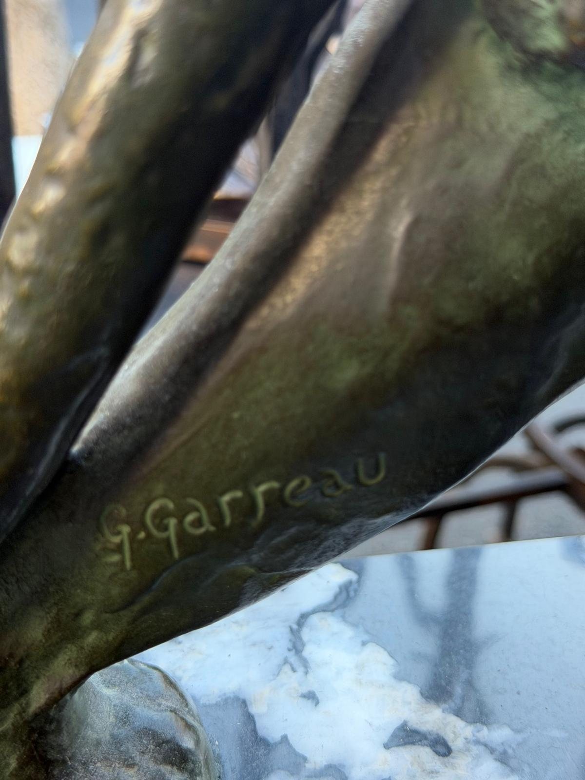 Signature G. Garreau gravée dans le bronze à patine verte, au-dessus du socle de marbre
