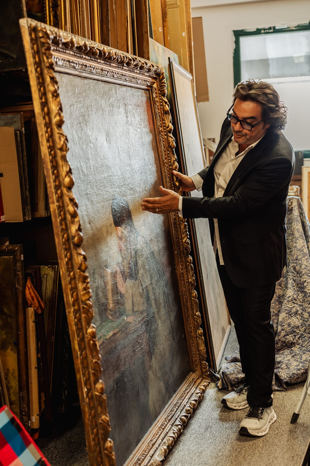 Le grand portrait posé contre les rayonnages : personnage de profil sur fond clair, peinture en pâte épaisse, cadre doré à large tore de feuillages