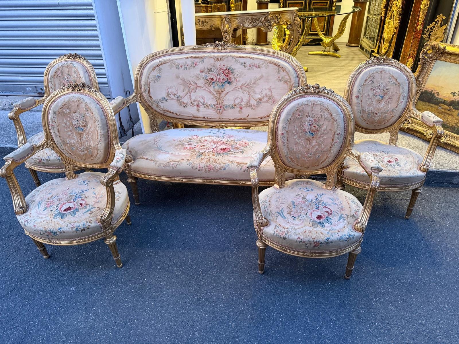 Le salon réuni : canapé et quatre fauteuils en bois doré garnis de tapisserie à fleurs, posés côte à côte