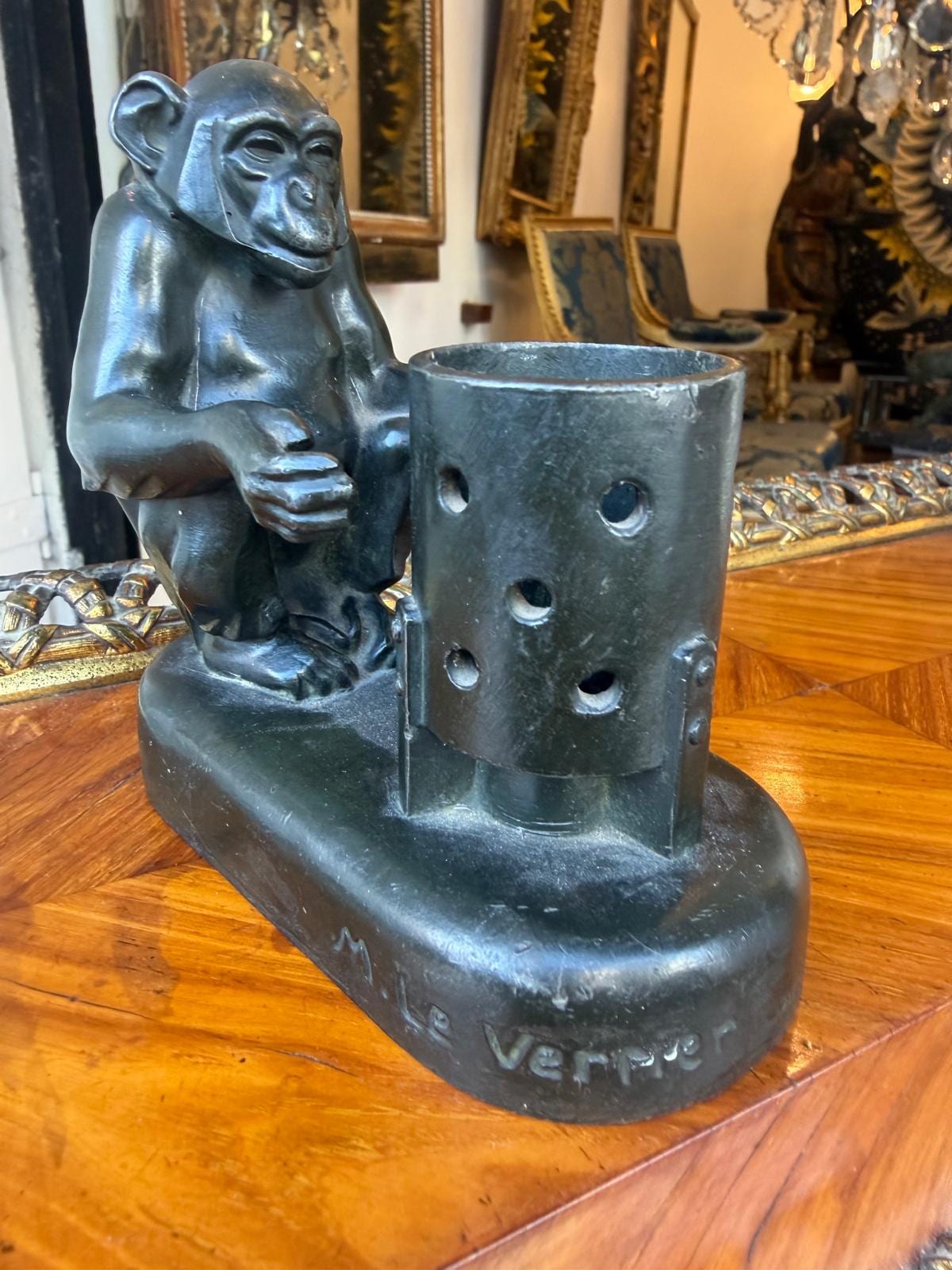 Vue rapprochée de la terrasse : signature « M. Le Verrier » en relief, à côté du brasero ajouré