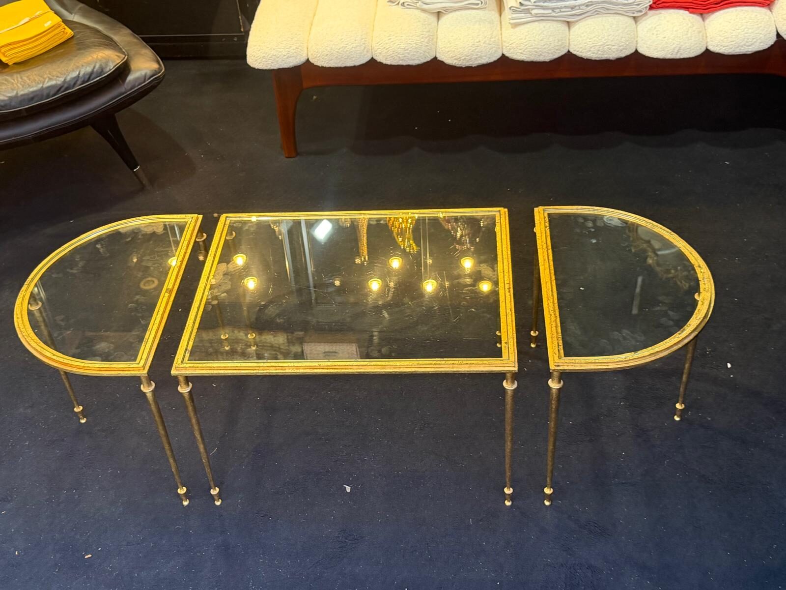 Les trois tables réunies en un long plateau aux extrémités arrondies, piétement fuselé doré à la feuille