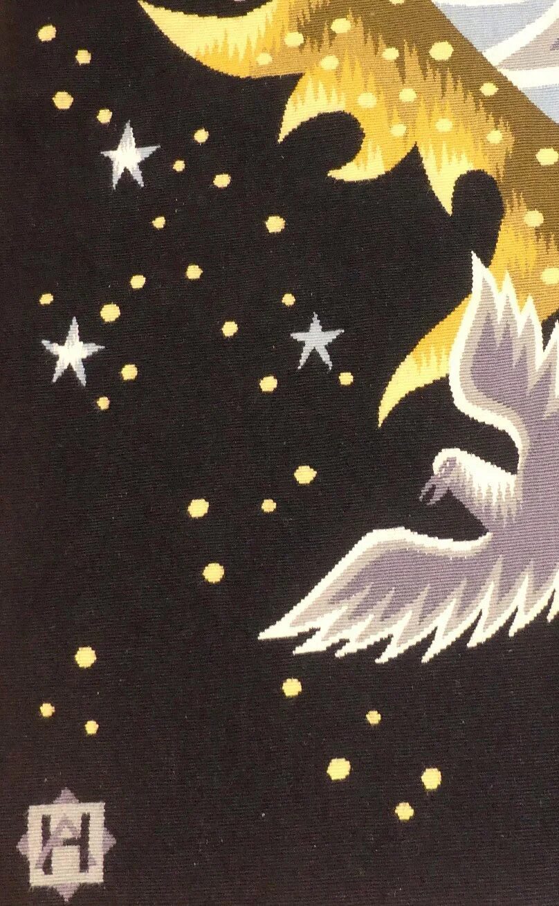 Colombe blanche et grise aux ailes déployées sur le fond noir semé d'étoiles et de points d'or, monogramme de l'atelier tissé dans l'angle