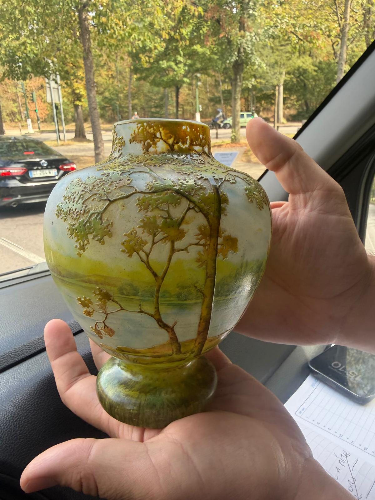 Le vase Daum Nancy tenu dans une main, ce qui montre sa petite taille de dix-neuf centimètres