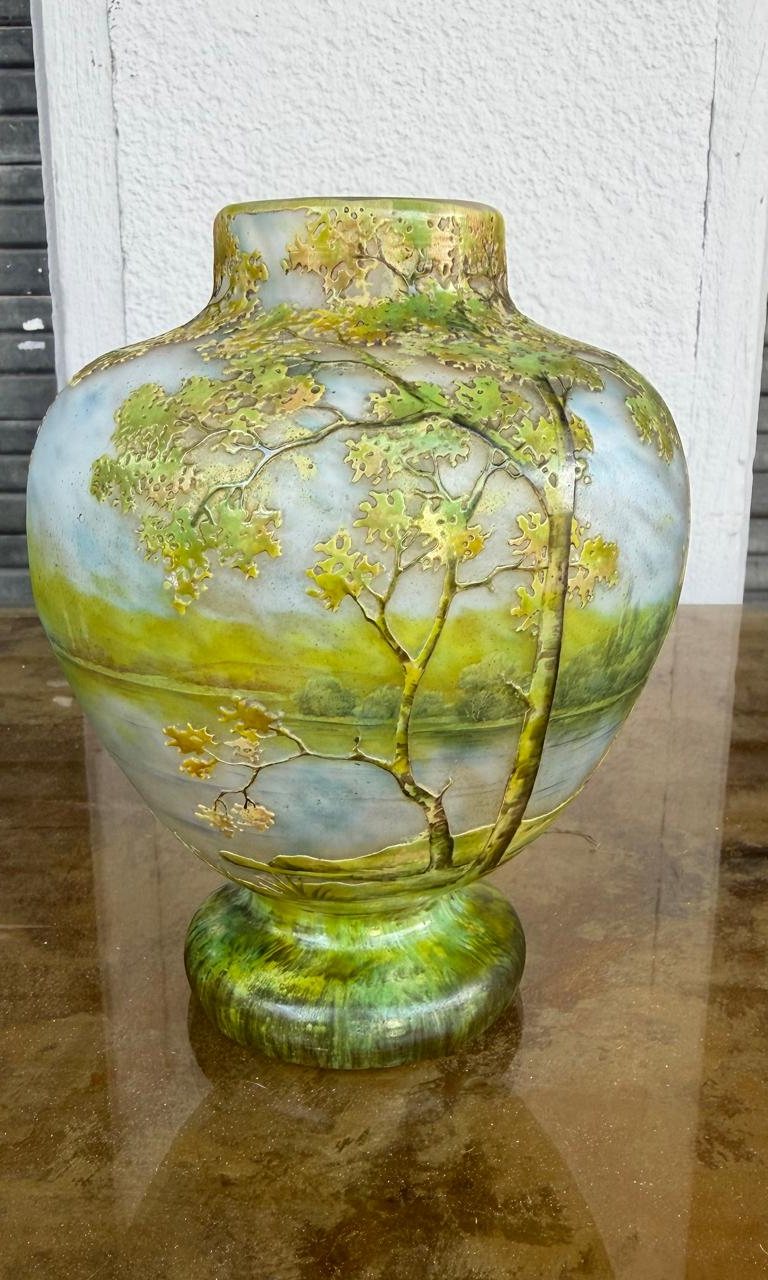 Vase Daum Nancy à décor de paysage lacustre, arbres au feuillage vert et jaune gravé à l'acide et émaillé, sur un pied de verre marmoréen vert